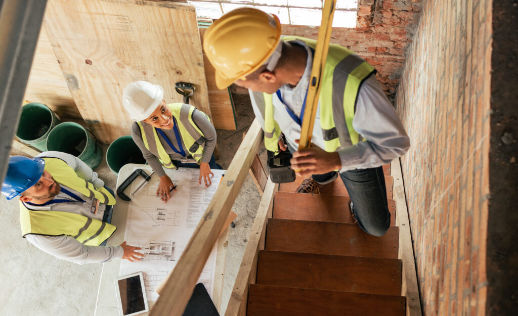 Top view, construction building and team planning with blueprint, collaboration and conversation. A